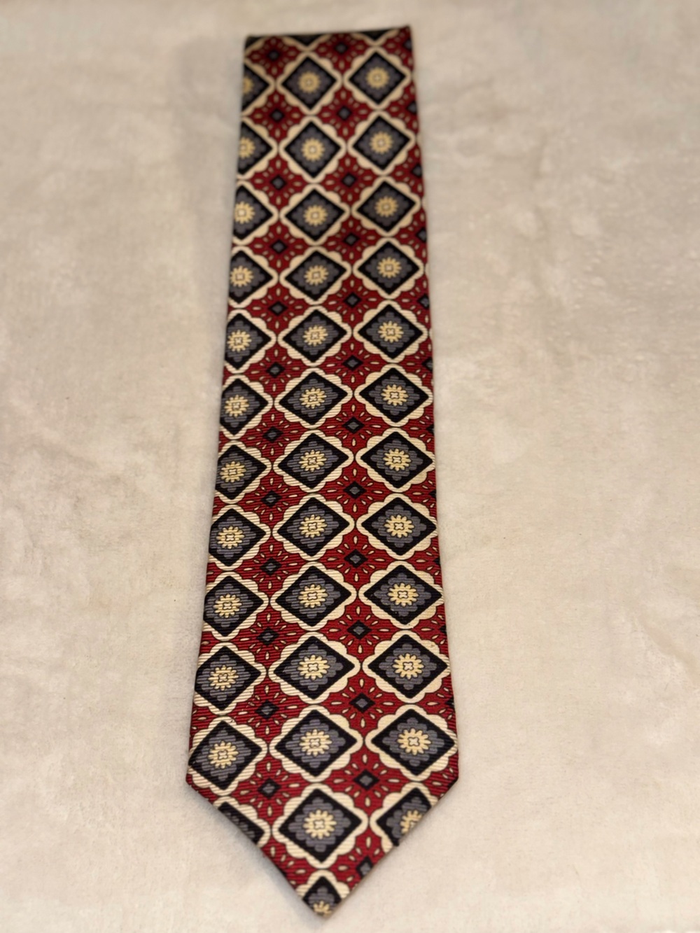 Tom James  Silk Necktie featuring a detailed Burgundy/Grey Geometric medallion